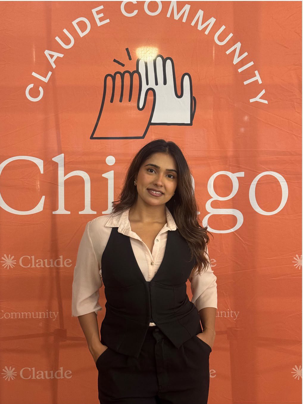 Bhavisha in front of the Claude Community Chicago backdrop at Build Day